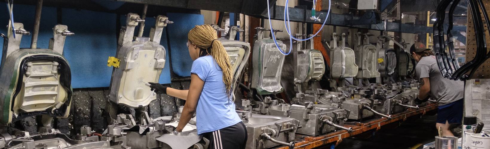 A women operating a seat molding machine at Sears Seating