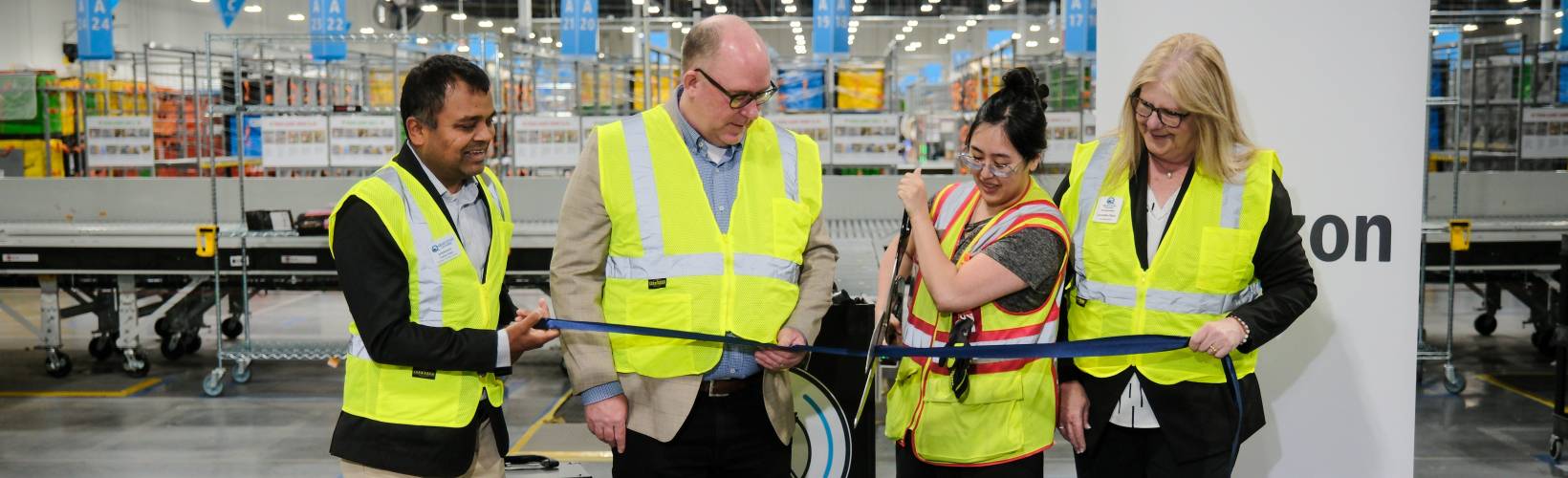 A lady cutting a ribbon with large scissors